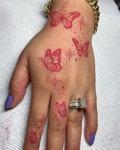 a woman's hand with butterfly tattoos on it