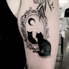 a woman with a tattoo on her arm has a cat and moon in the frame