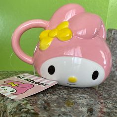 a pink hello kitty mug sitting on top of a counter