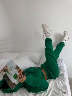 A model lounging on her bed in a stylish Yuri green sweat set, reading a Vogue magazine, highlighting the ultimate cozy and fashionable outfit for relaxed days. Matching Hoodie And Sweatpants Outfit, Outfits For Long Flights, Hoodie And Sweatpants Outfit, Sweat Suits Outfits, Comfy Airport Outfit, Matching Sweat Set, Crewneck Outfit, Cute Sweats, Green Lounge