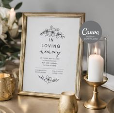 a white and gold wedding sign on a table next to some candles with flowers in the background