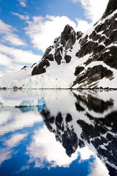 an iceberg is reflected in the still water