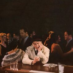 a man sitting at a table in front of a group of people