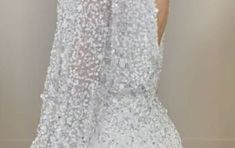 the back of a woman's wedding dress with sequins and beads on it