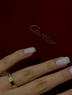 a woman's hand with white nails and gold ring