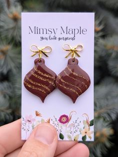 Bold Burgundy Ornament-Shaped Polymer Clay Earrings 🎄 Celebrate the Season with Sparkle! 🎄 Add a touch of festive flair to your holiday collection with our stunning bold burgundy ornament-shaped polymer clay earrings! Each earring features shimmering gold sparkling glitter details that dance throughout the design, creating a striking visual effect. Features: Design: Beautifully cut into ornament shapes, these earrings are perfect for holiday celebrations or year-round elegance. Finish: Sealed Christmas Ornament Clay Earrings, Handmade Multicolor Holiday Earrings, Santa Clause Clay Earrings, Christmas Sweater Polymer Clay Earrings, Handmade Multicolor Christmas Earrings, Handmade Holiday Gifts, Sparkles Glitter, Handmade Holiday, Simple Jewelry