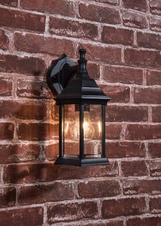 an outdoor light on the side of a brick wall