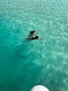 a person floating in the ocean on top of a boat