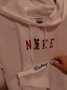 someone holding onto a mickey mouse hoodie with the word'n e on it