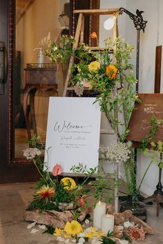 a wedding sign surrounded by flowers and candles