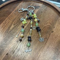 a close up of a wooden table with beads and charms on it's side