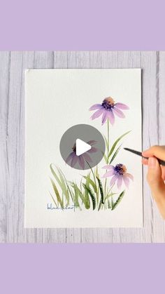 someone is painting flowers with watercolors on paper