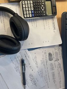 headphones, calculator and pen on top of papers