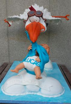 a cake shaped like a cartoon character on top of a blue sheet with an orange beak