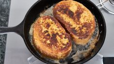 two pieces of french toast cooking in a skillet