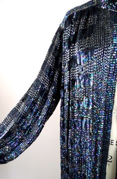 "This is another DAZZLING vintage glam coat! It's all hand embellished with iridescent black sequins and glass beading and is in perfect condition! Bust - measures 60\" with the front brought together Shoulders - 18\" hem to hem Sleeves - 25\" Arm Circumference - measures 20\" around Length - 35\" from top to bottom hem All of my items come from a smoke-free and pet-free home. If you have any questions, please don't hesitate to ask!" Festive Party Outerwear With Mirror Work, Glamorous Beaded Party Outerwear, Vintage Blue Outerwear For Party, Blue Embellished Party Outerwear, Bohemian Style Embellished Outerwear For Party, Bohemian Embellished Party Outerwear, Bohemian Party Outerwear With Sequins, Blue Sequined Outerwear For Party, Party Blue Sequined Outerwear