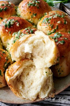 a plate filled with rolls covered in cheese and herbs