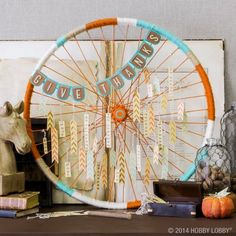 there is a bicycle wheel on the shelf next to some books and other things in front of it