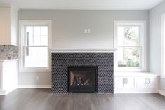 an empty living room with a fireplace and windows