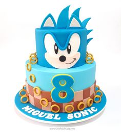 a sonic the hedgehog birthday cake on a white background with blue and gold decorations