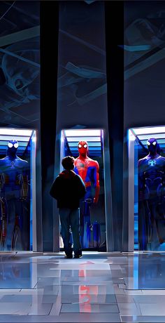 a man standing in front of three mannequins wearing spider - man costumes