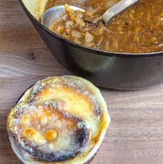 a pan filled with food next to a bowl full of soup on top of a wooden table