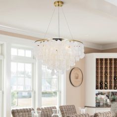 a dining room table with chairs and a chandelier hanging from it's ceiling