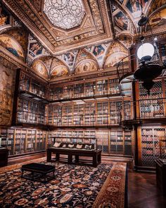 a room with many bookshelves and a table in the middle, all covered by intricately designed rugs