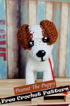 a small white and brown dog sitting on top of a wooden table next to a sign that says, peanut the puppy free crochet pattern