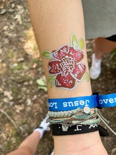 a woman's arm with two bracelets on it that have flowers painted on them