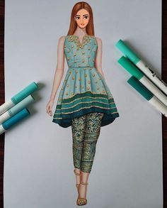 a drawing of a woman with red hair and green dress on top of paper next to markers