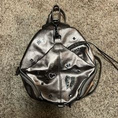 Brand New Never Used Beautiful Disaster Faux, Leather Mini Backpack!!!! Trendy Leather Crossbody Backpack With Zipper, Trendy Leather Crossbody Backpack With Zipper Closure, Trendy Faux Leather Backpack With Zipper Pocket, Trendy Backpack With Leather Backing, Trendy Faux Leather Backpack With Detachable Strap, Trendy Leather-backed Bag For On-the-go, Trendy Leather-backed Backpack, Faux Leather Backpack With Detachable Strap, Travel Backpack With Zipper Closure In Silver