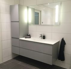 a bathroom with a sink, mirror and towel rack in it's center area