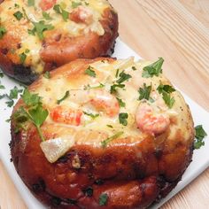 two baked goods on a plate with parsley sprinkled around the top and sides