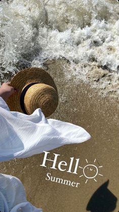 a woman in white dress and straw hat standing on the beach next to water with words hello summer