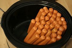 carrots in a black crock pot on a counter top, with the tops turned upside down