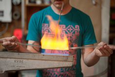 a man is working on something in the air with a stick and flame coming out of it