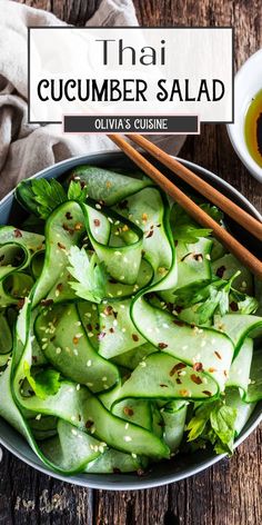 a bowl filled with cucumber salad and chopsticks next to it on top of a wooden table