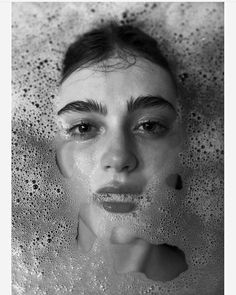 a woman is in the bathtub with bubbles on her head and eyes are visible