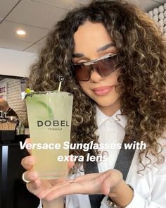 a woman wearing sunglasses holding a drink in her hand with the words dobel on it