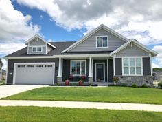 a gray house with white trim and two car garages