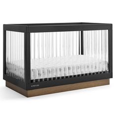 a baby crib with white sheets in it