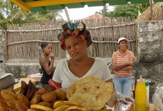 a woman standing behind a table filled with food