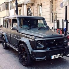 a mercedes g - class is parked on the side of the street