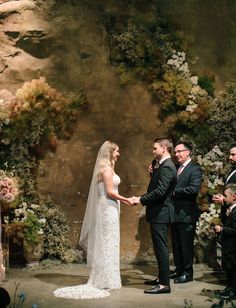 the bride and groom are getting married in front of an outdoor altar with floral arrangements