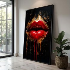 a painting with red lips and gold splatters on it next to a potted plant