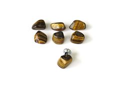 several different types of tiger's eye beads on a white surface with one bead in the middle