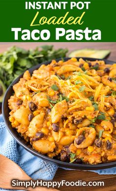 a bowl filled with pasta and beans on top of a blue towel next to vegetables