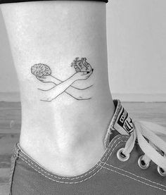 a woman's foot with a small tattoo on the side of her leg and an object in the middle