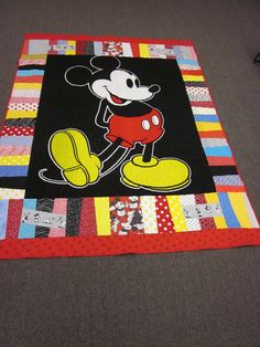 the mickey mouse quilt is laying on the floor